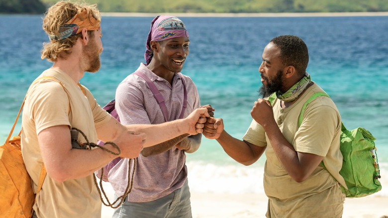 Trois joueurs de Survivor se frappent le poing