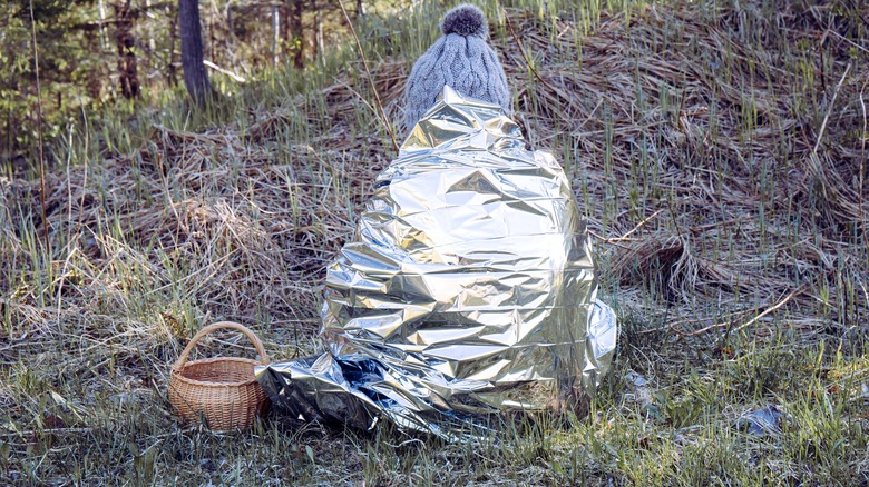 Campeur perdu enveloppé dans une couverture thermique 