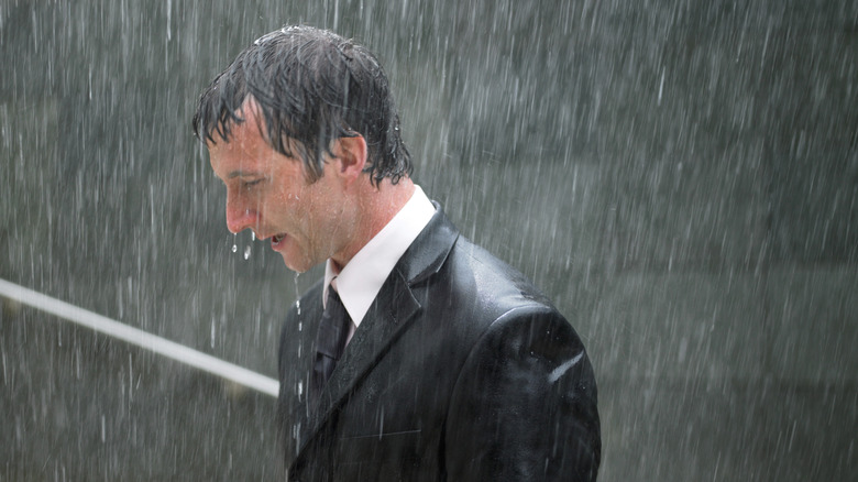 Homme en costume debout sous la pluie