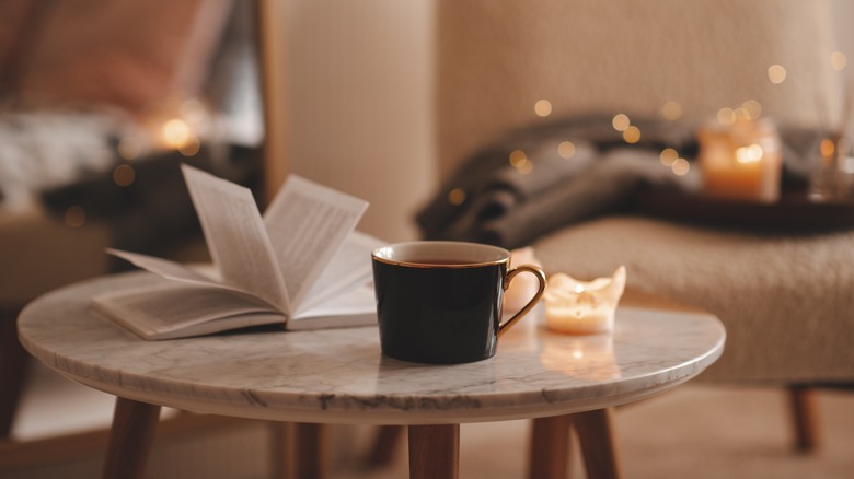 Tasse à thé, table à thé, livre, bougies