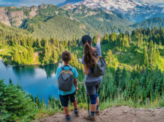 Mère et fils au sommet d'une chaîne de montagnes avec un lac