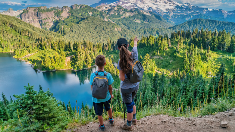 Mère et fils au sommet d'une chaîne de montagnes avec un lac