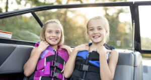 enfants sur un bateau avec gilet de sauvetage