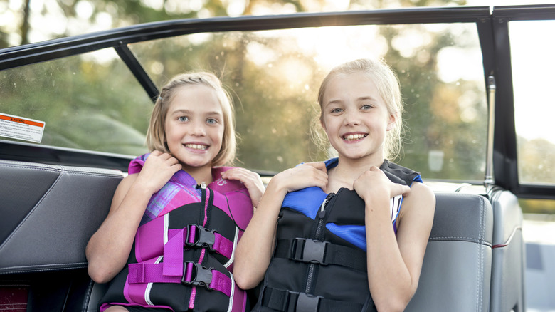 enfants sur un bateau avec gilet de sauvetage