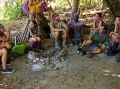 Les membres de la tribu des survivants sont assis autour du feu 