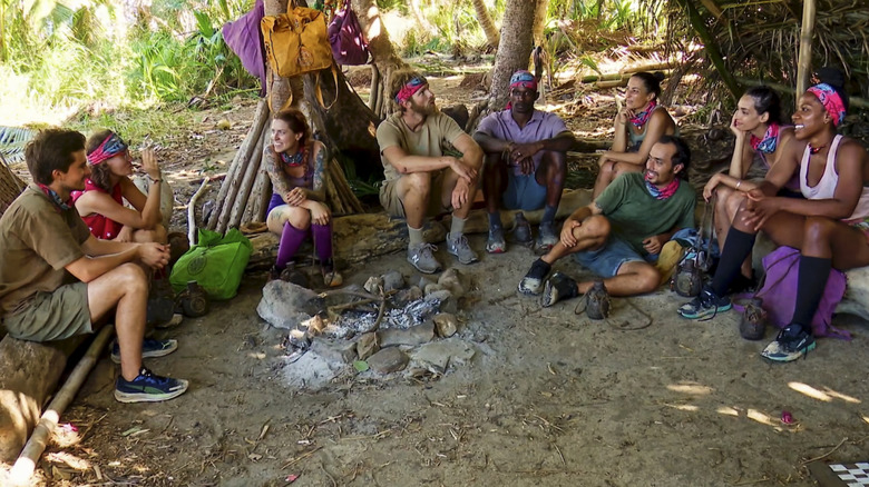 Les membres de la tribu des survivants sont assis autour du feu 