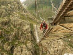 Un homme traverse le pont de Trift en Suisse