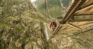 Un homme traverse le pont de Trift en Suisse