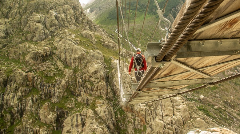 Un homme traverse le pont de Trift en Suisse