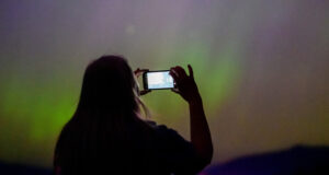 Une dame prenant des photos d'aurores boréales 