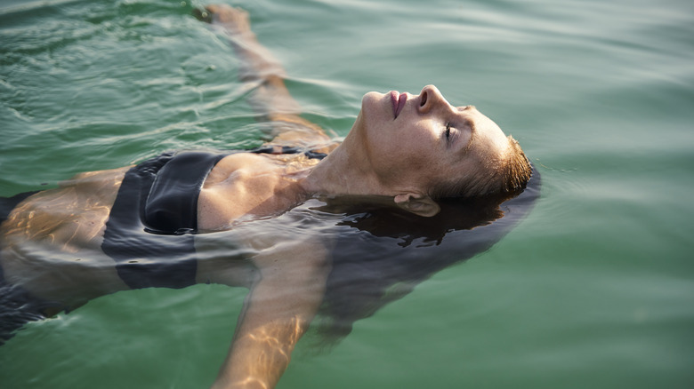 femme flottant sur le dos dans l'océan