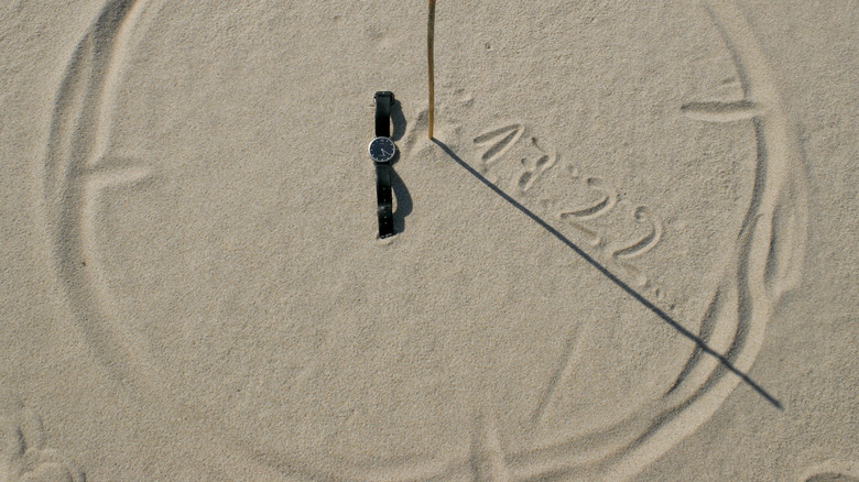 cercle dans le sable avec bâton et ombres