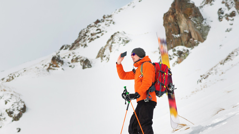 Skieur avec téléphone en montagne