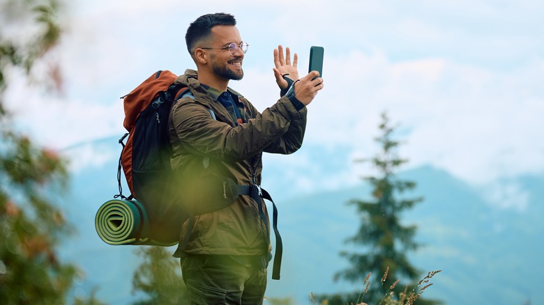 Homme au téléphone pendant une randonnée